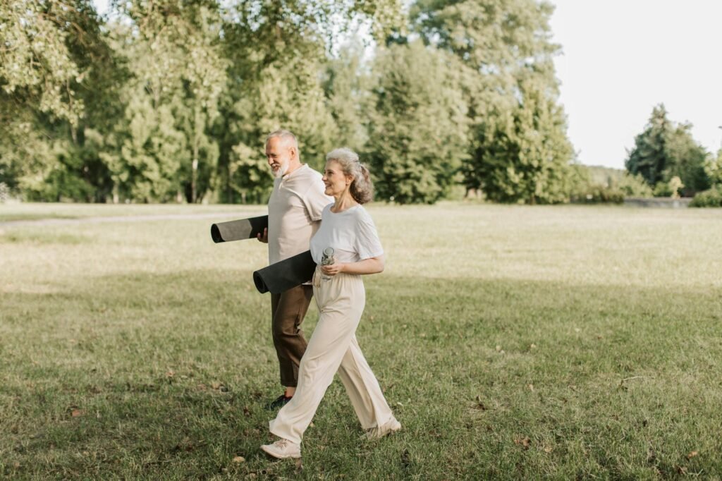 Cuplu de vârstnici plimbându-se în parc pentru exercițiu fizic moderat